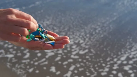 Person holding microplastics collected from the ocean shore. Stock Footage 330686692