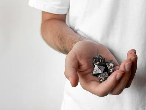 Person holding polyhedral dice set: gaming and role-playing symbolism Foto stock