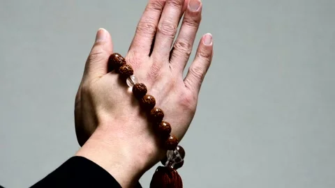 A person holding prayer beads and praying Stock Footage 336042018