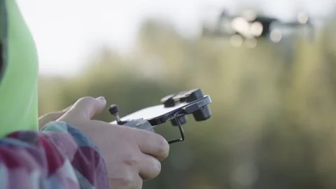 A person is holding a remote control and flying a drone Stock Footage 306960508