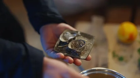 A person is holding a small silver object with a spoon in it Video stock 295367549