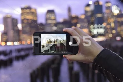 Person Holding A Smart Phone, Taking A Photograph Of A City Skyline