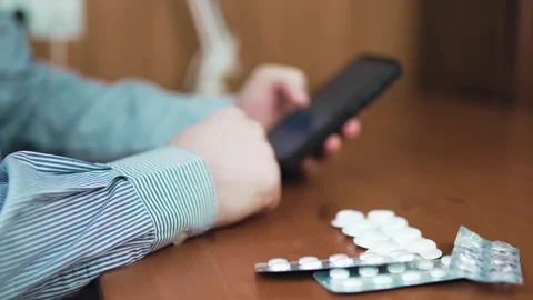 Person holding smartphone and checking prescription online with medical pil.. Stock Footage 340159799