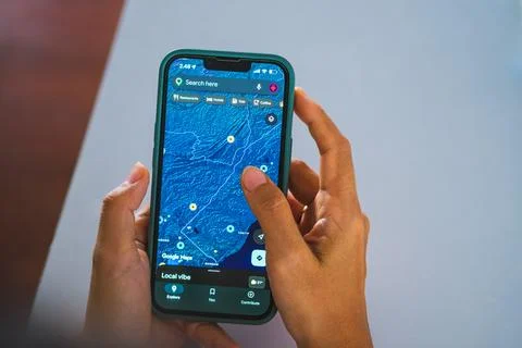 Person holding smartphone displaying digital satellite terrain map 写真素材
