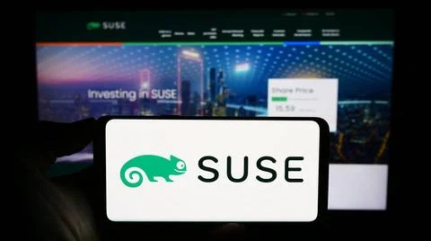  Person holding smartphone with logo of open-source software company SUSE ... Foto stock
