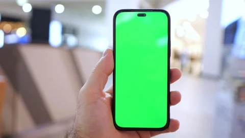 Person holding smartphone with solid green display Stock Footage 345672266