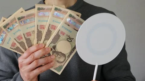 A person holding a stack of bills and a round stick Stock Footage 324544255