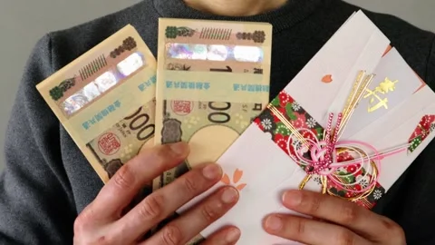 A person holding a stack of bills and a gift envelope Stock Footage 324546500