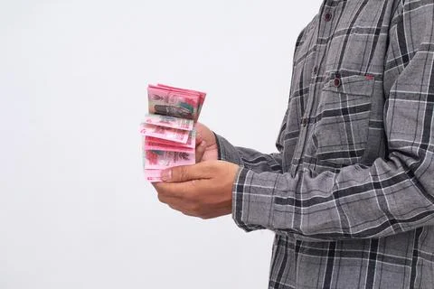 Person Holding Stack Of Currency Notes Against Plain Background Stock Photos
