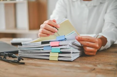 A person is holding a stack of papers on a desk 库存照片