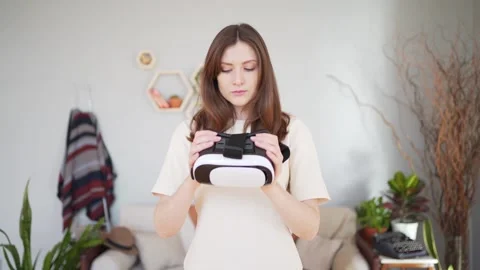 The person is holding a virtual reality headset and looks into it. Cyberspace in Vidéo 149658750