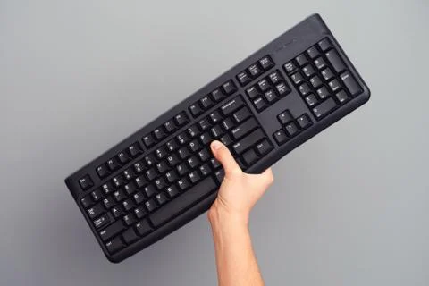 Person holds black wireless keyboard in her hand Foto stock
