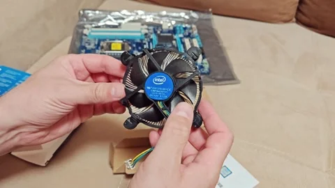 A person holds a computer processor cooler. Aluminum heat sink fan Stock Footage 314339256