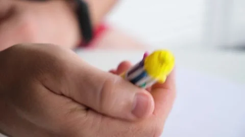 The person holds in hand a multi-colored ballpoint pen, the nibs of which slide Stock Footage 323638614