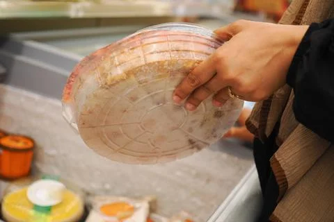 A person holds a pack of flatbread while shopping in a store Stock Photos