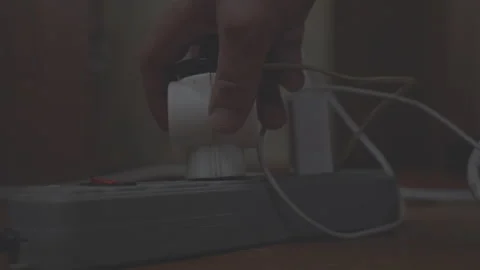 Person holds plug from electrical appliance and inserts it into extension socket Stock Footage 253664534