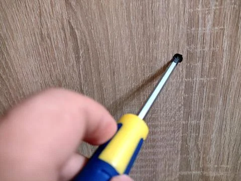 A person holds a screwdriver in his hand Фото