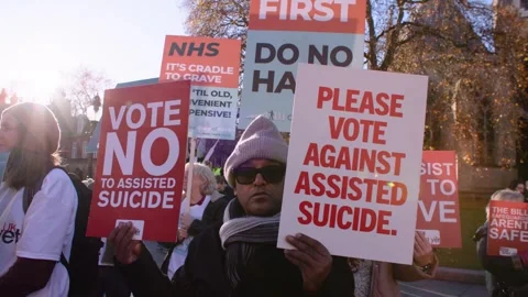 Person holds two placards opposing the Assisted Dying bill Vidéo 293843959