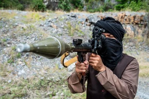 Person holds weapon while aiming at target in outdoor location during dayli.. Stock Photos