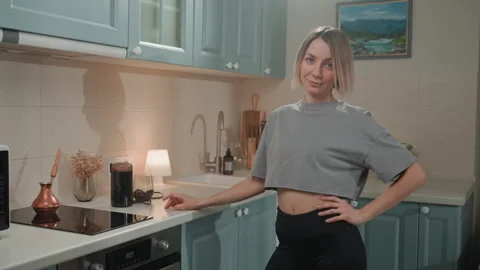 Person hums quietly while enjoying peaceful kitchen melodies daily. Woman in Stock Footage 342064089