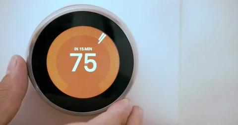 A person increasing the temperature on a Smart Thermostat on fahrenheit scale Stock Footage 163706957