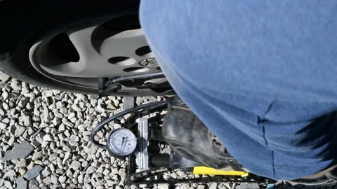 Person inflating vehicle tyre using foot pump Stock Footage 144373664