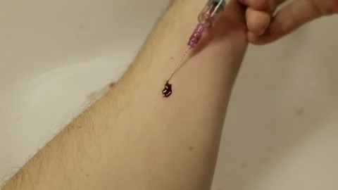 Person Injecting Syringe Into Arm Vein With Blood Droplet Stock Footage 329052475