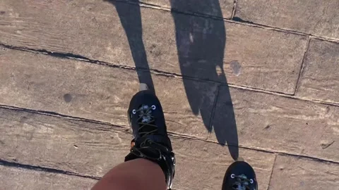 Person inline skating, top-down shadow view across pavement Stock Footage 345361746
