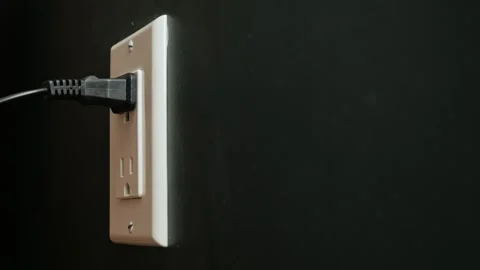 Person inserting and removing black power cord into electrical wall outlet .. Stock Footage 334658176