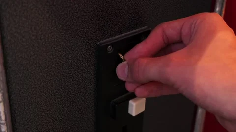 Person inserting coin into arcade game machine slot Stock Footage 340280850
