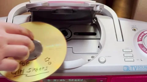 A person inserting a Music compact disc or CD a digital optical disc data Stock Footage 259337177
