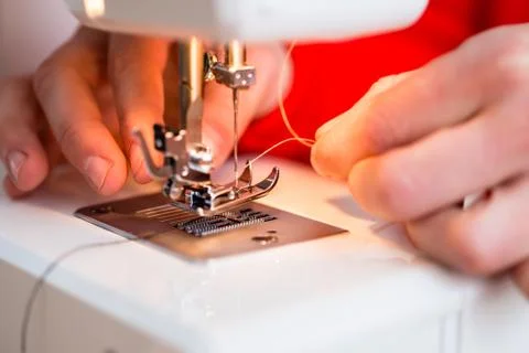 Person inserting thread in to a needle Foto stock
