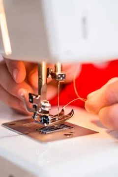 Person inserting thread in to a needle Foto stock