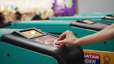 Person inserting token coin into arcade game machine Stock Footage 344845596