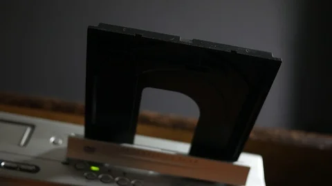 Person inserts a DVD laser disc into the DVD player and pushes it into the tray  Vidéo 90104015