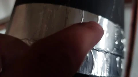 Person inspecting taped pipe joint with aluminum foil tape close up Stock Footage 345230635