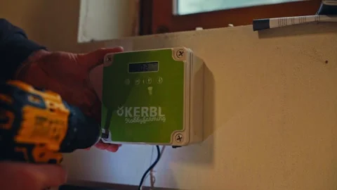 A Person is Installing an Electronic Control Box on a Wall Indoors - Close Up Stock Footage 335016709