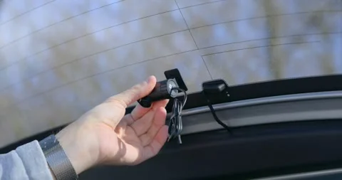 Person installing a rear dashcam on a car window Stock Footage 332058126