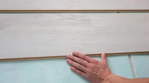 Person installing wall panels in a modern home interior Stock Photos