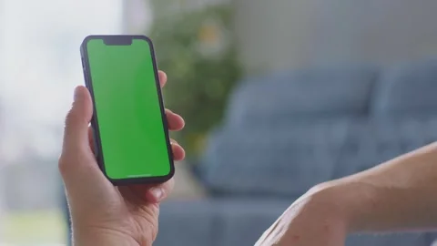 Person interacting with green screen smartphone while holding device in han.. Stock Footage 337523137