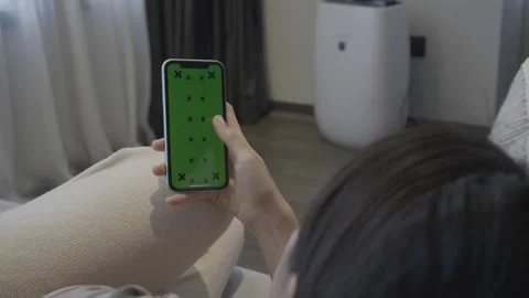 Person Interacting with Mobile Phone While Relaxing at Home Stock Footage 314511964