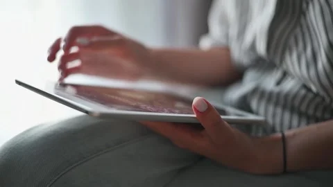A person interacts with a tablet, scrolling and tapping while sitting near a Vidéo 336778593