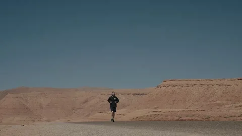 Person Jogging Alone on Desert Road Morocco Stock Footage 340595293