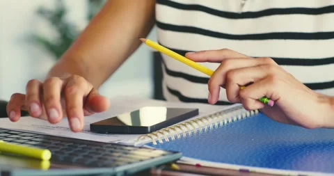Person Jotting Notes and Using Laptop at Desk Video stock 323580580