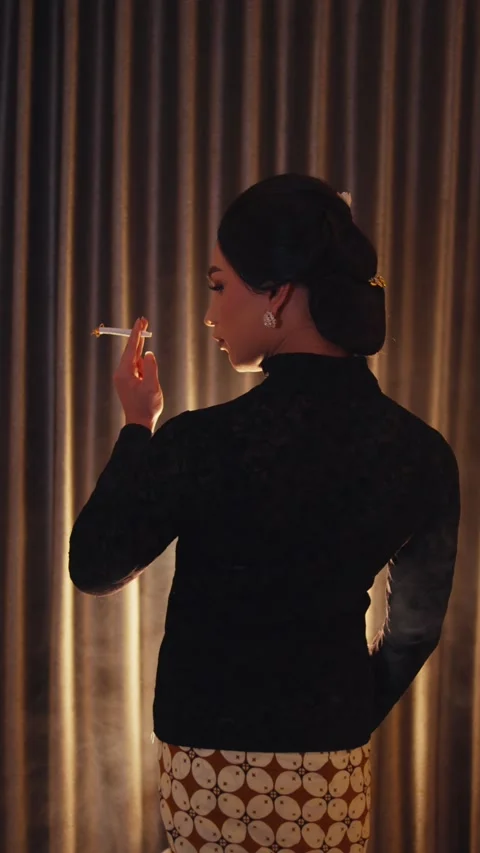 Person in Kebaya Turns From Behind While Smoking Stock Footage 262519111