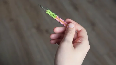 Person knocks down the temperature on a mercury thermometer, a close-up, a Stock-Footage 126968056