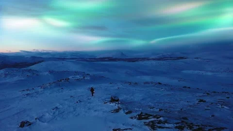 Person with a lantern hiking in arctic highlands, aurora sky, Saana Stock Footage