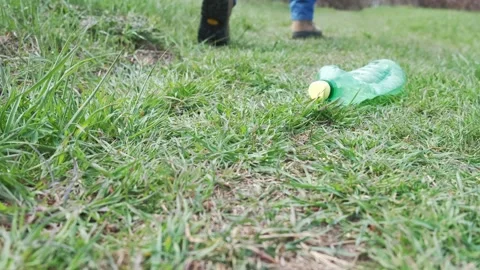 Person left used plastic bottle on green grass in the forest Video stock 151170620