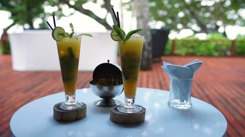 A person lifting up a cocktail and placing it back on a coaster Stock Footage 101661453