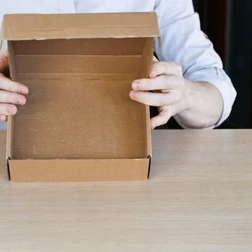 Person lifting open empty box to show interior Stock Photos